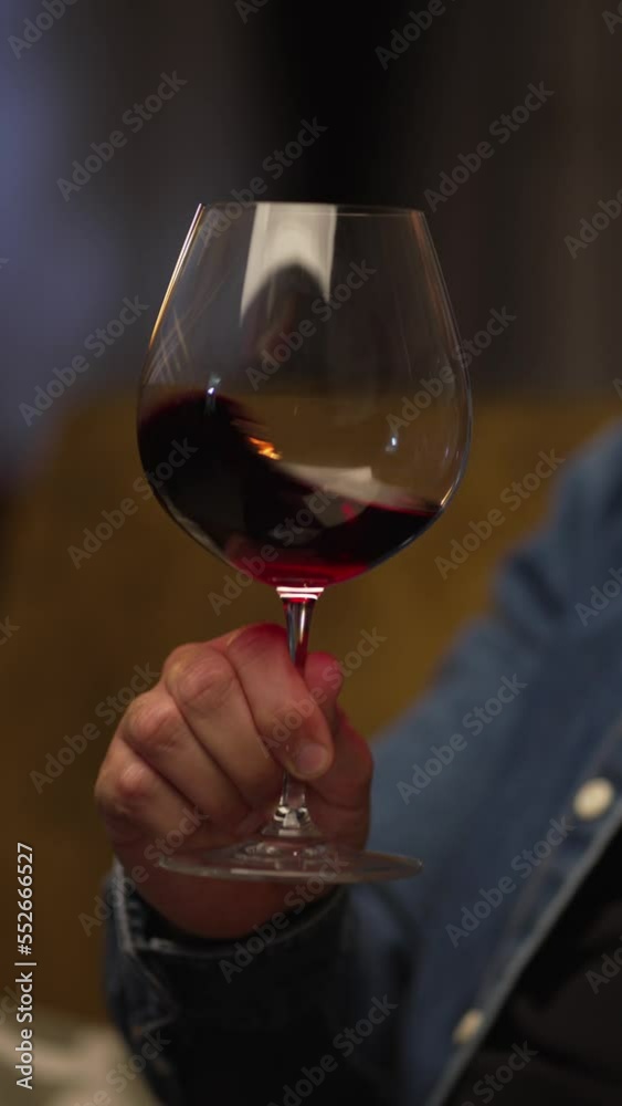 Man sitting in dark room drinking tasting red wine from wine glass. Man sitting in dark room drinking tasting red wine from wine glass.