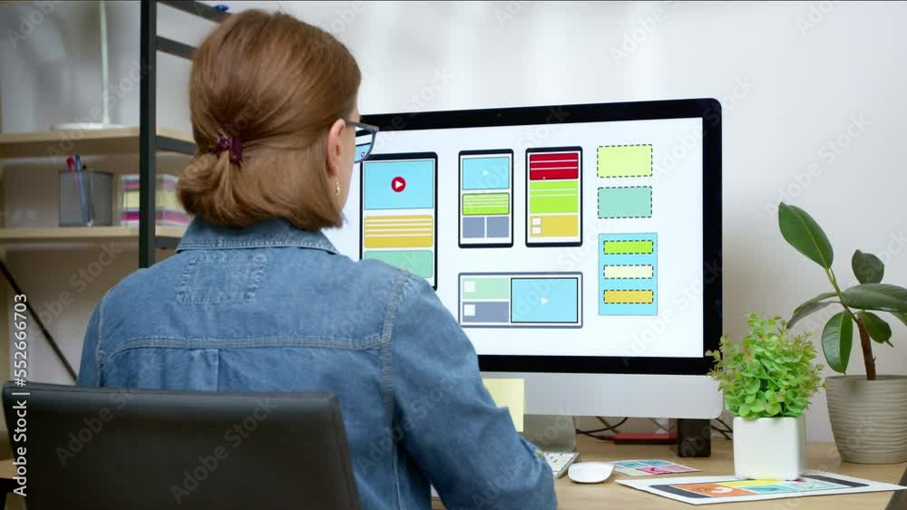 A UI designer develops a web site interface using a computer. Creation of an application for smartphones.
