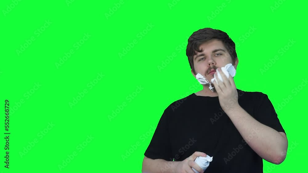 Man with beard applies white foam for shaving face. Clip. Green screen with copyspace. Chroma key. Man with beard applies white foam for shaving face. Clip. Green screen with copyspace. Chroma key.