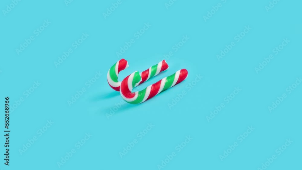 Creative Christmas and New year concept with candy cane on pastel blue background 4k. Creative Christmas and New year concept with candy cane on pastel blue background 4k.