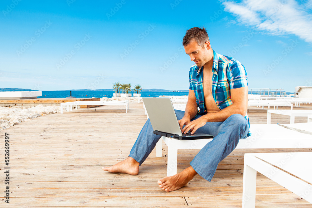 Man with the laptop on the beach