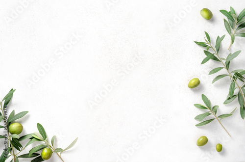Olives and olive branches on white textured background. Background with olive leaves for your package and design.