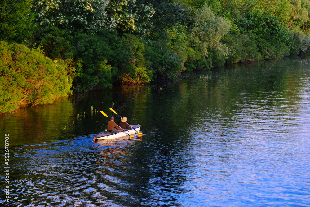 A couple of people are kayaking on the river.
