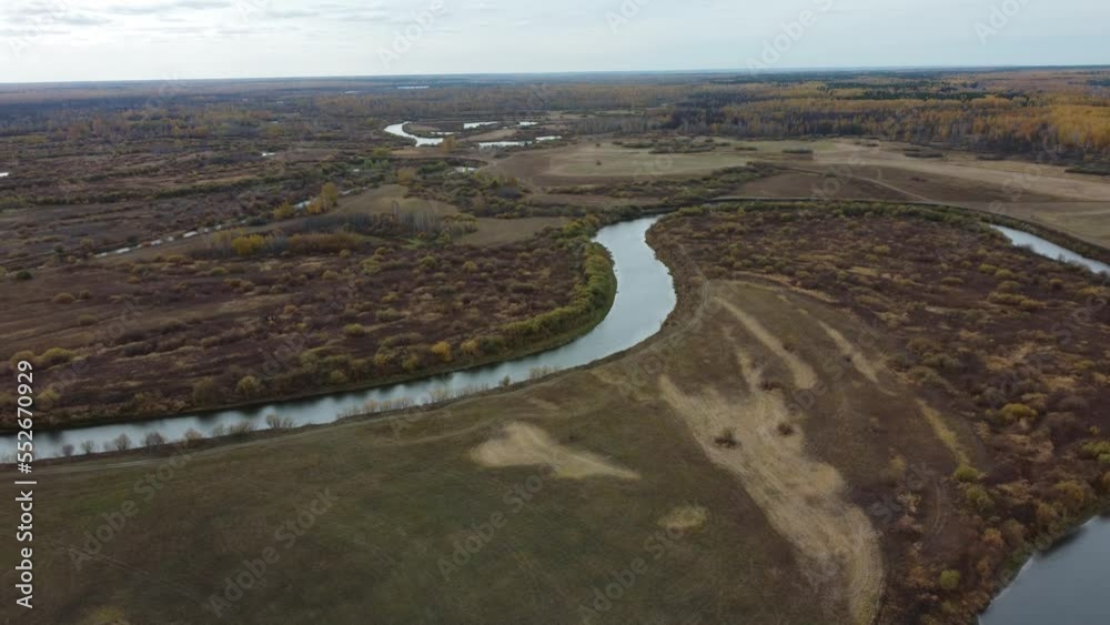 Autumn flight of a drone over a field and a river Autumn flight of a drone over a field and a river