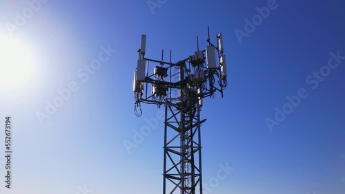 Aerial view of tower antennas with telecommunication, cell phone and radio transmitters. Around view at golden hour evening with sun leaks. Cellular signals for 5g, 4g mobile data and smart phones. photo