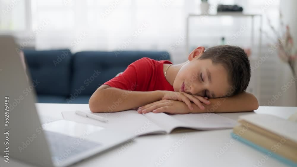 Cute schoolboy sleeping on desk, no motivation to do homework, exhausted child Cute schoolboy sleeping on desk, no motivation to do homework, exhausted child