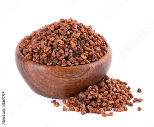Buckwheat tea in wooden bowl, isolated on white background. Whole roasted buckwheat grains. Fagopyrum tataricum.