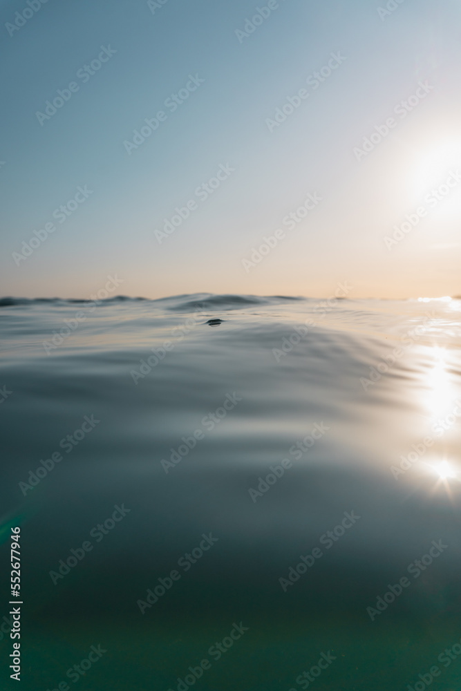 Fototapeta premium Sunset at the beach. Orange sky at horizon and blue ocean.