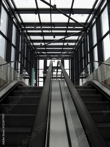 A pair of escalators with glass railing from underground floor to exit stock photo for vertical story 