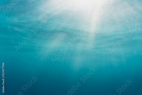 Underwater vision of sun ray light. Turquoise ocean.