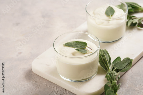Creamy dairy yoghurt dessert sweet mousse with mascarpone, cream cheese, sage and lemon juice in glasses on marble tray