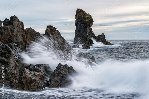 Waves crash against the shoreline of Djupalonssandur beach at sunset, Snaefellsness Peninsula; Iceland photo