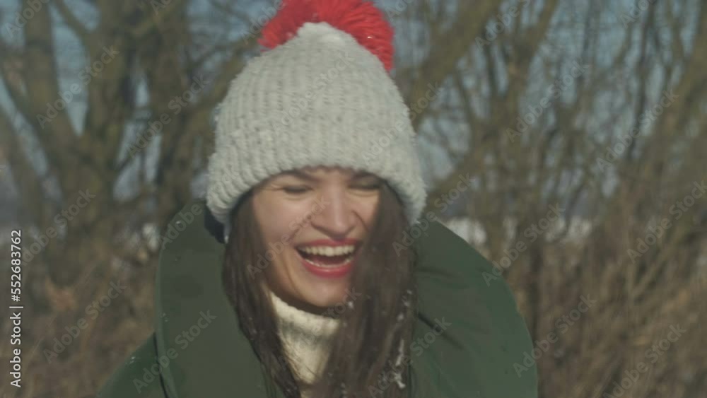 Portrait of a cheerful young woman playing snowballs with someone. Portrait of a cheerful young woman playing snowballs with someone.