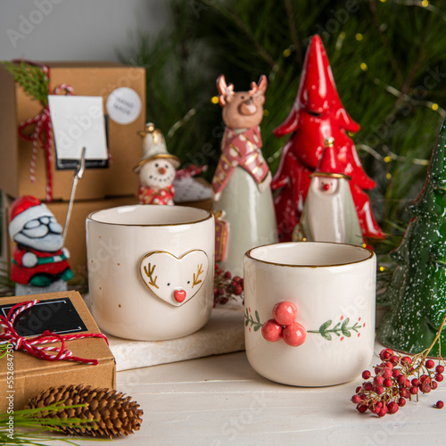 christmas decorated ceramic coffee cups with gift boxes and christmas tree