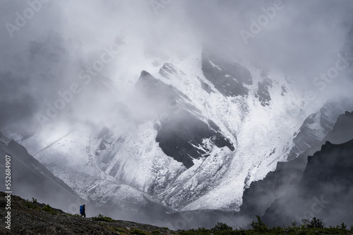 Lone hiker trekking in front of a huge and amazing landscape in Kluane National Park, Yukon. photo
