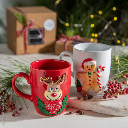 christmas decorated ceramic coffee cups with gift boxes and christmas tree