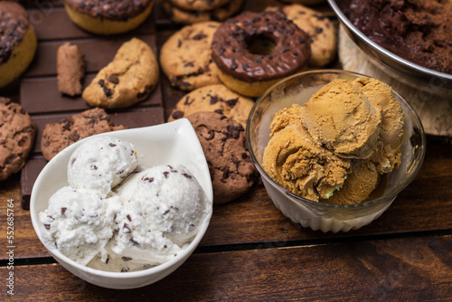 A sweet table containing ice cream, donuts and chocolate chip cookies