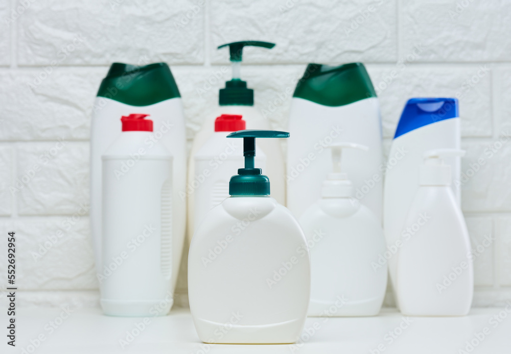 White plastic container with a pump for liquid products on a white shelf. Container for cosmetics White plastic container with a pump for liquid products on a white shelf. Container for cosmetics