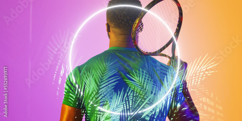 Illuminated circle and plants over rear view of african american male tennis player holding racket