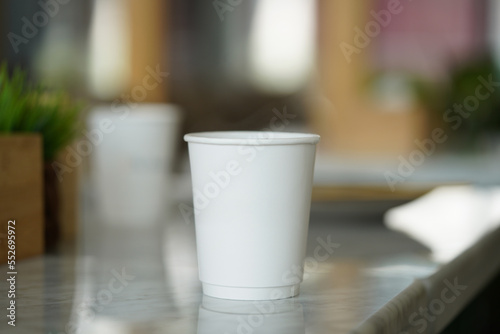 One white paper cup on a cafe table  a White cafe paper cup. 3d rendering  mockup.                 