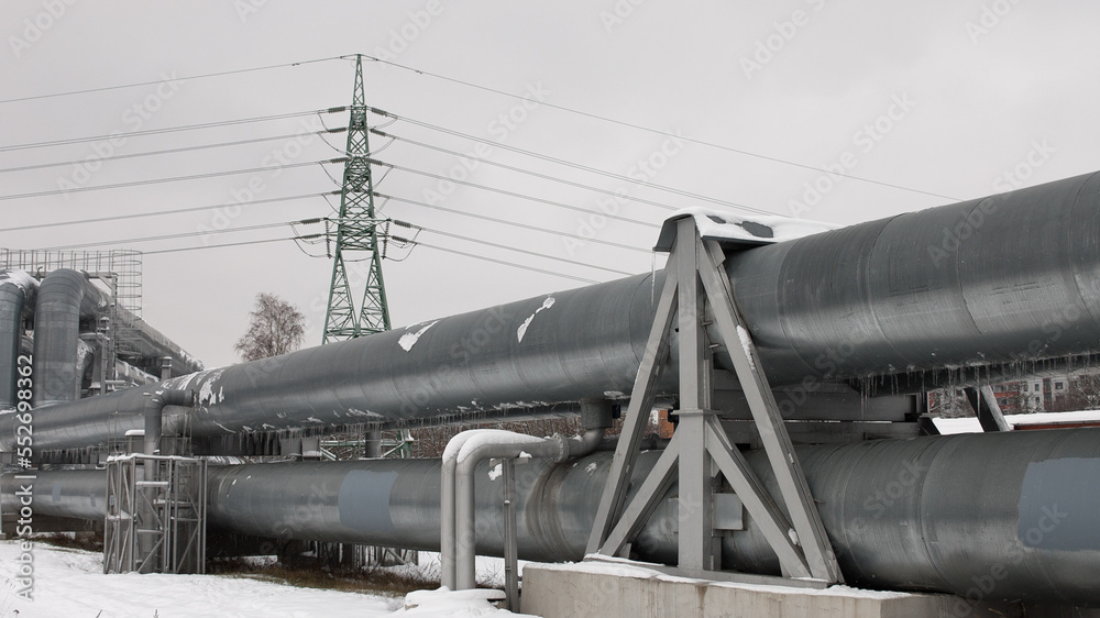 pipeline and power line in the city in winter against the gray sky. pipeline and power line in the city in winter against the gray sky.