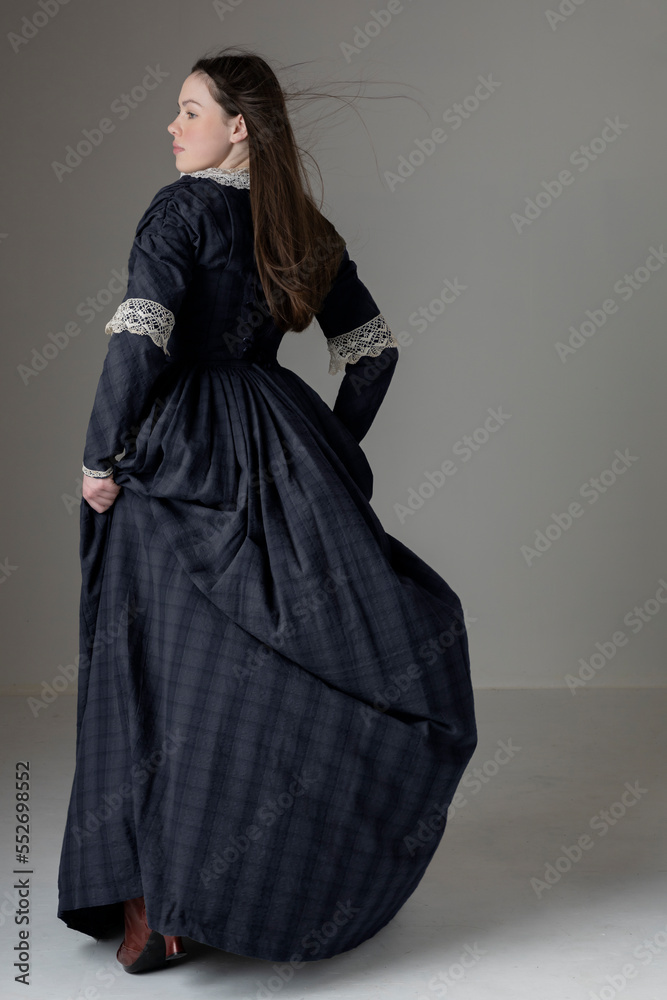 A young Victorian woman wearing a blue cotton dress with lace trim A young Victorian woman wearing a blue cotton dress with lace trim
