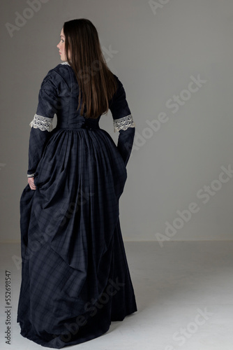 A young Victorian woman wearing a blue cotton dress with lace trim