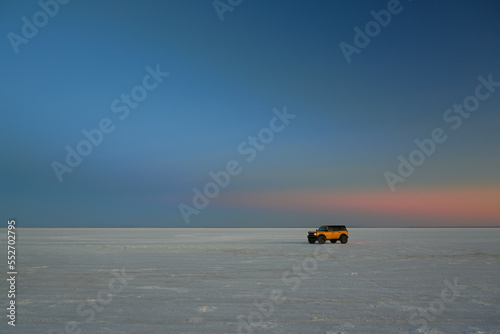 Orange Ford Bronco parked on the Bonneville Salt Flats near Wendover, Utah at twilight photo