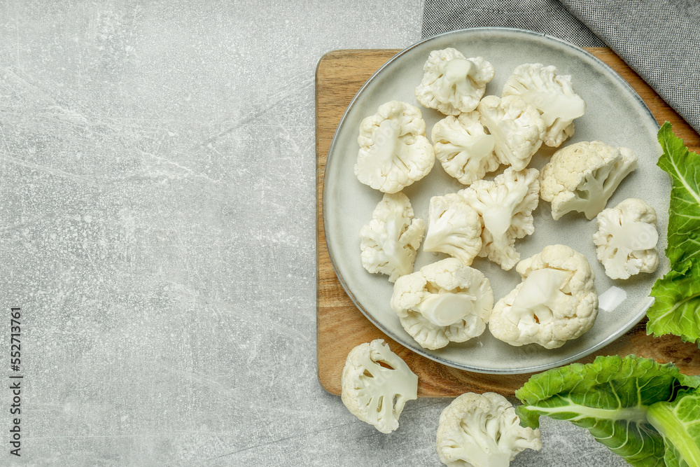 Cut fresh raw cauliflowers on grey table, top view. Space for text Cut fresh raw cauliflowers on grey table, top view. Space for text