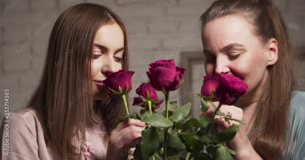 Two beautiful women and a bouquet of red roses. Two beautiful women and a bouquet of red roses.
