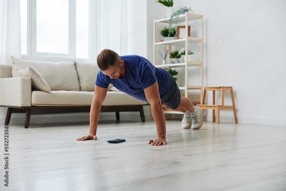 Man sportsman training at home, stretching exercises for arm, leg and back muscles, strong body and correct posture, the concept of health and beauty