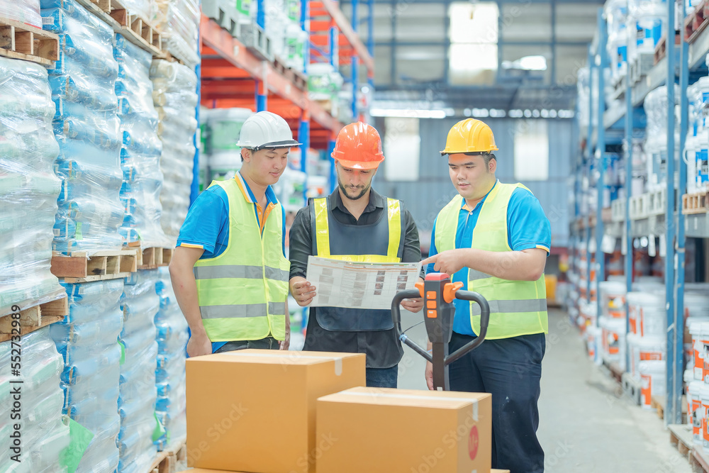 Warehouse workers in helmets checking goods and supplies on shelves with goods background in warehouse worker packing in a large warehouse in a large warehouse. Logistics industry concept.. Warehouse workers in helmets checking goods and supplies on shelves with goods background in warehouse worker packing in a large warehouse in a large warehouse. Logistics industry concept..