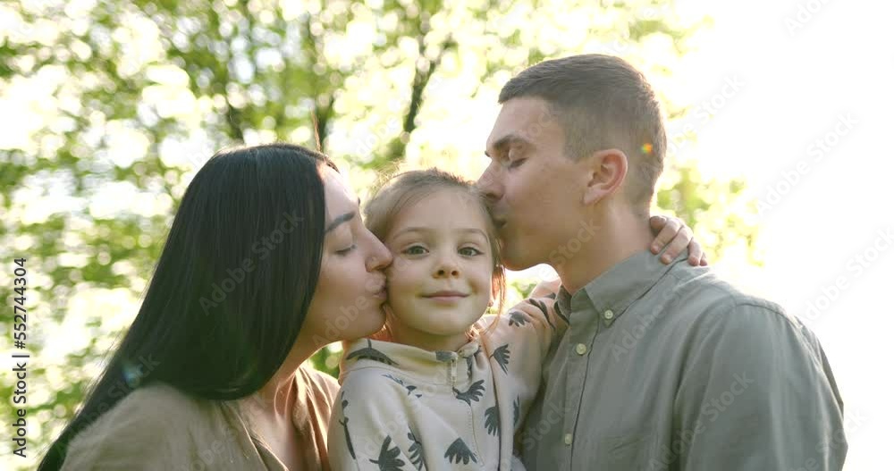 Family of three hugging in the summer park Family of three hugging in the summer park