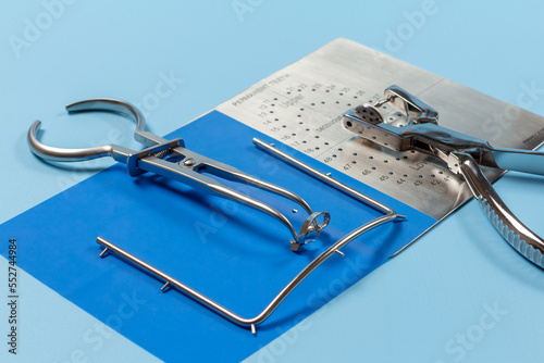 Dental hole punch, the rubber dam forceps and the metal plate.