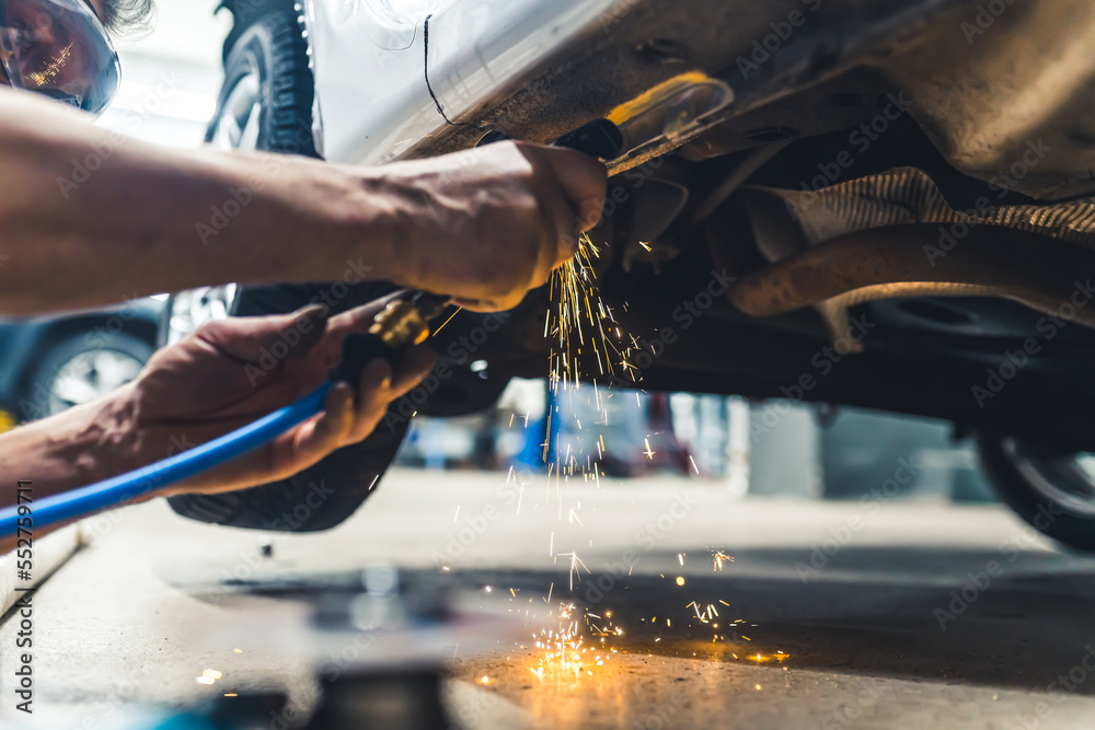 Bluecollar worker concept. Angle grinder in use. Dangerous heat sparkles. Two hands of