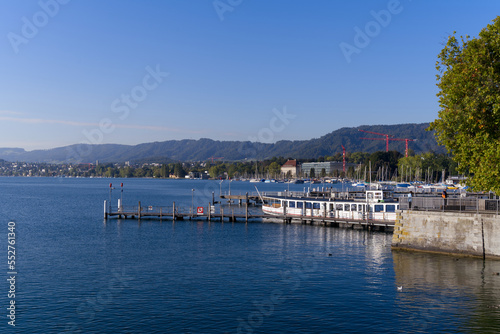 Scenic view over Lake Zürich seen from City of Zürich with pier and Swiss Alps in the background on a sunny late summer day. Photo taken September 22, 2022, Zurich, Switzerland.