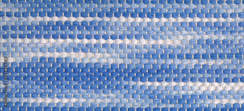 Closeup of handwoven rag rug in white and blue shades. photo