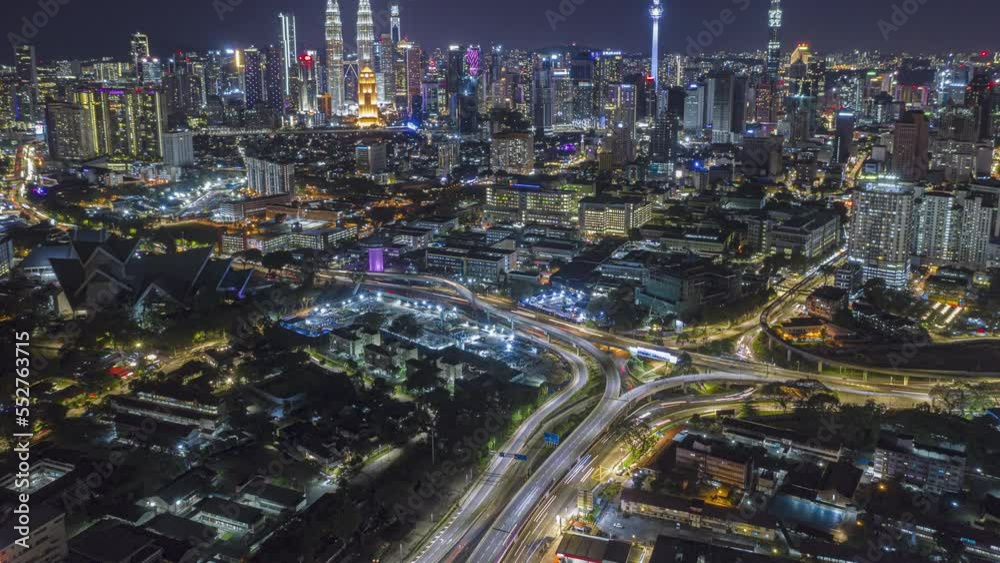 Aerial time lapse overlooking a busy roundabout and city streets against a city skyline in the background at night with city lights in Kuala Lumpur, Malaysia. Prores 4KUHD Aerial time lapse overlooking a busy roundabout and city streets against a city skyline in the background at night with city lights in Kuala Lumpur, Malaysia. Prores 4KUHD