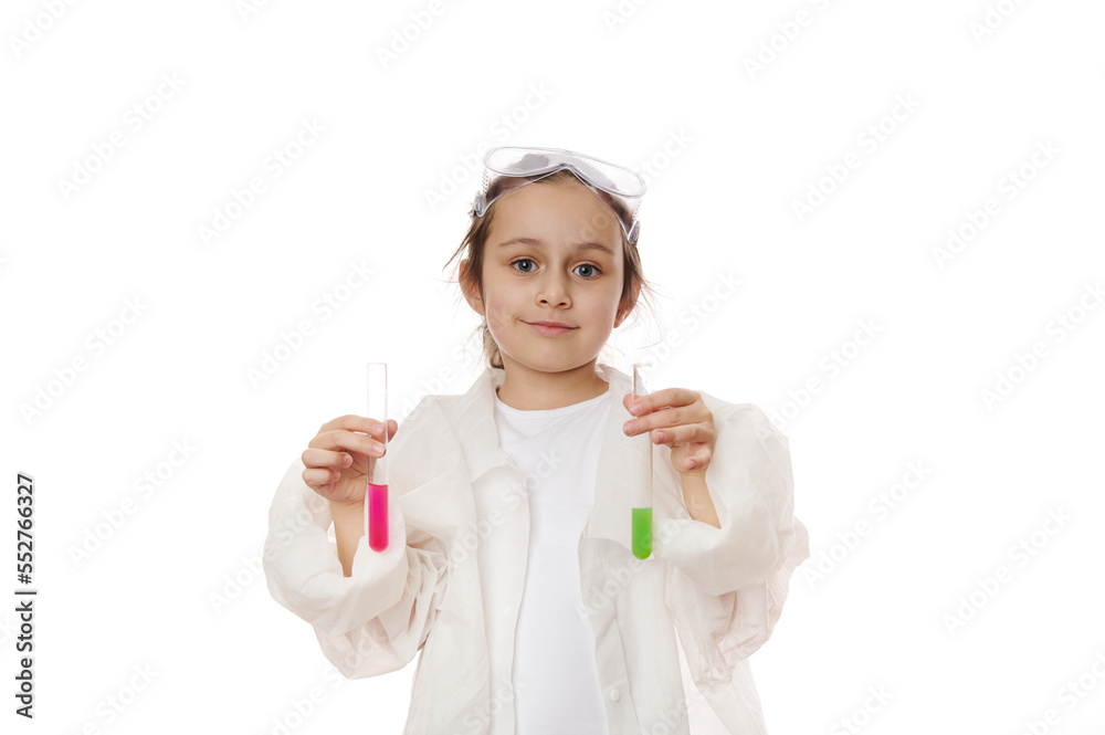Lovely child girl, future chemist scientist in lab coat, smiles looking at camera, holding out test tubes with liquid chemical, isolated on white background. Kids learning chemistry. Education concept Lovely child girl, future chemist scientist in lab coat, smiles looking at camera, holding out test tubes with liquid chemical, isolated on white background. Kids learning chemistry. Education concept