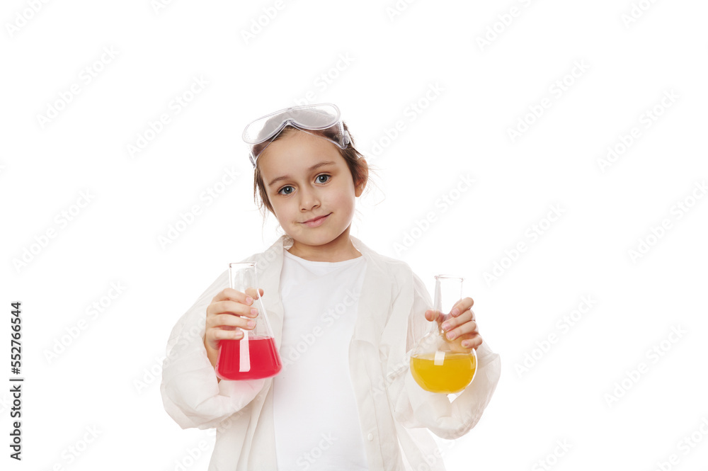Smart primary school student, cute little girl in lab coat, posing with laboratory flasks with colorful chemical solutions, isolated white background. Chemistry Science. Education concept. Copy space Smart primary school student, cute little girl in lab coat, posing with laboratory flasks with colorful chemical solutions, isolated white background. Chemistry Science. Education concept. Copy space