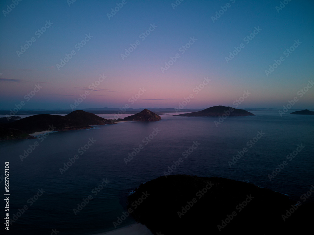 Drone photo from Fingal Beach to Tomaree Mountain in Port Stephens, just prior to sunrise. Drone photo from Fingal Beach to Tomaree Mountain in Port Stephens, just prior to sunrise.