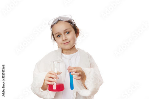 Happy smart little girl, primary school student, future chemist scientist in lab coat, holding test tube and lab flask, doing chemistry experiment, on white background. Profession and science concept