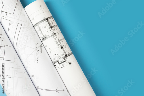Architectural blueprint rolls on a blue background, copy space