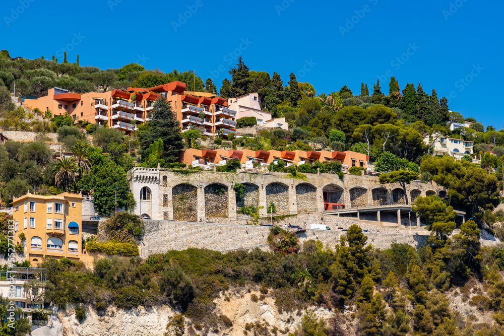 Residential area rising above harbor beach onshore Azure Cost of Mediterranean Sea in Villefranche-sur-Mer resort town in France