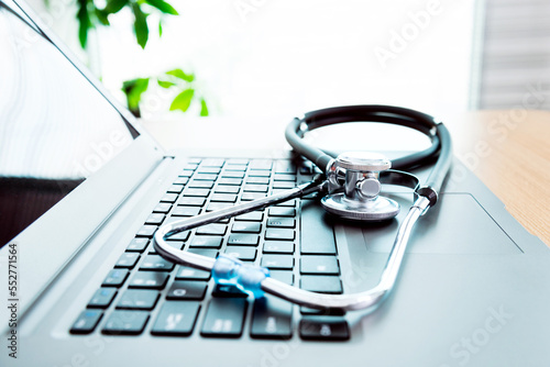 Stethoscope and laptop on doctor working desk