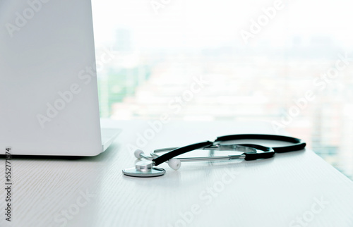 Stethoscope and laptop on doctor working desk