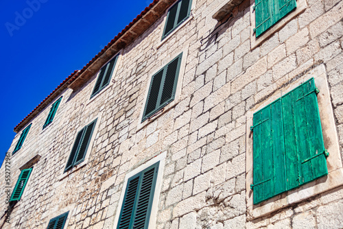 Brick wall with windows with shutters . White bricks and green windows  photo