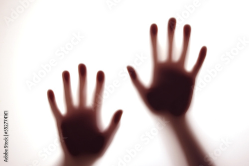 Blurred shadows of hands behind glass, concept of ghosts, zombies, walking corpses