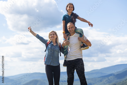 Family hiking parents with child outdoor travel in mountains active vacations lifestyle mother and father backpacking together.