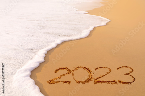 Obraz na plátně Welcoming The year 2023 handwriting on sand beach, Happy New Year coming concept